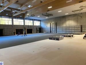 Bild zeigt die neue Halle mit dem Sportboden, welcher momentan verlegt wird